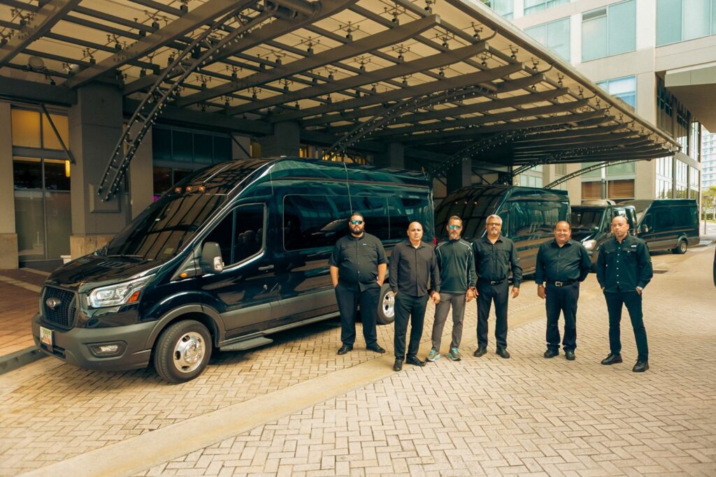 Team of private drivers standing beside their black passenger vans at a San Juan hotel