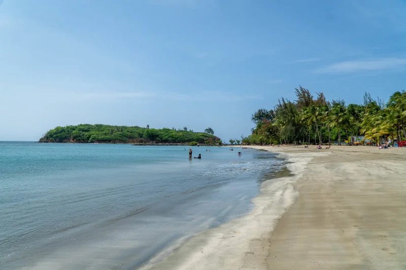 Punta Salinas beach in Toa Baja with calm water and the green islet at the point
