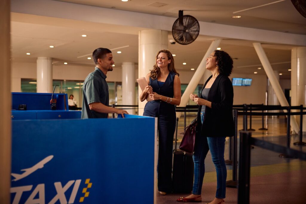 Travelers asking for a ride at the taxi stand inside the San Juan airport