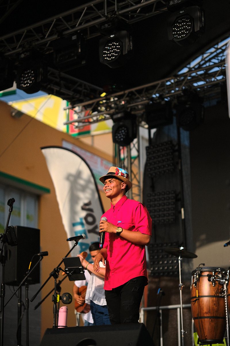 Young singer smiling on stage at a town festival in Toa Baja, Puerto Rico